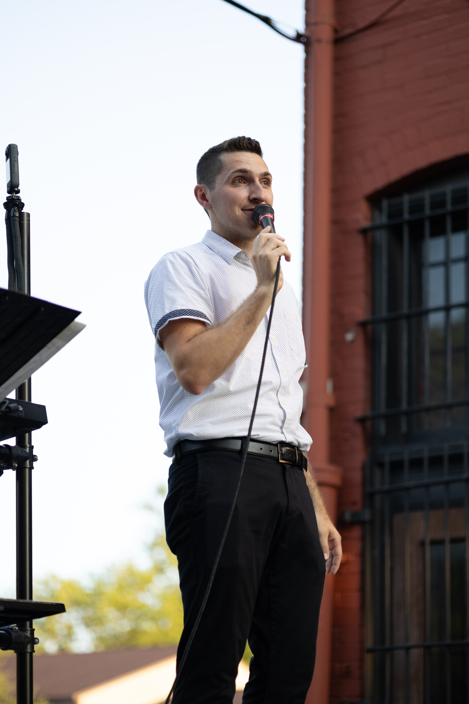 Nico Ruggieri singing on a stage in the Selah Alleyway. A speaker and keyboard are set up behind him.