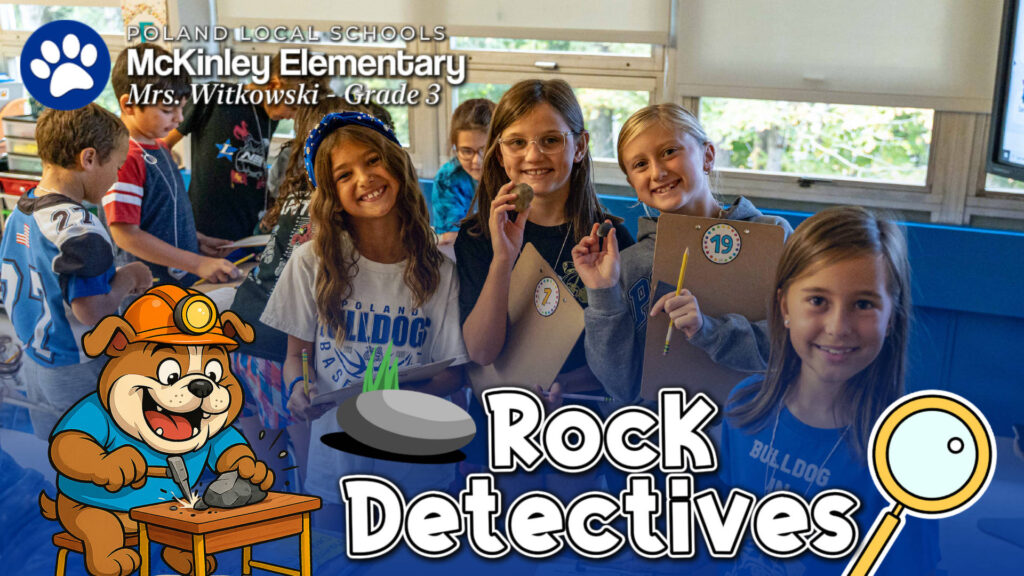 Group of third grade students at McKinley Elementary smile while holding rocks and clipboards during a classroom science activity themed aro